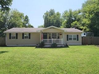 single story home with a front lawn and a porch