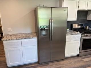 kitchen featuring light stone counters, white cabinets, and stainless steel appliances