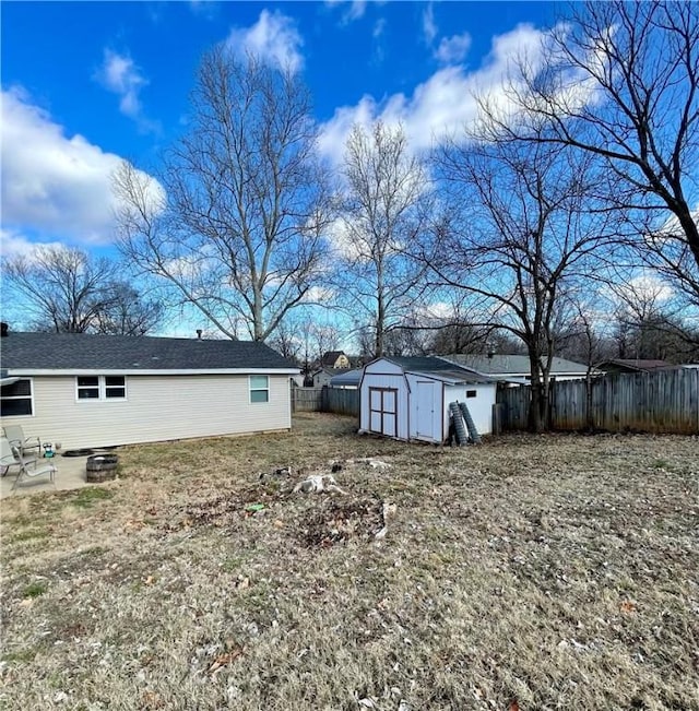 view of yard featuring a patio area, an outdoor fire pit, and a storage unit