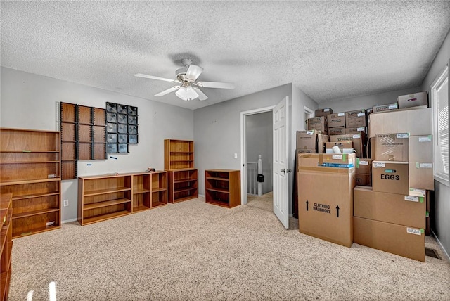 interior space with ceiling fan, light colored carpet, and a textured ceiling