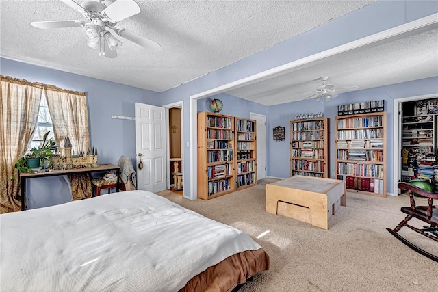 carpeted bedroom featuring a closet, ceiling fan, and a textured ceiling