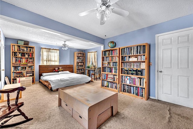 bedroom with ceiling fan, light colored carpet, and a textured ceiling