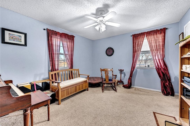 living area featuring ceiling fan, a textured ceiling, and carpet flooring