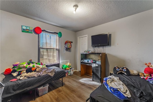 bedroom with wood-type flooring and a textured ceiling