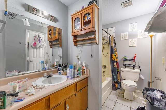 full bathroom featuring toilet, a textured ceiling, shower / tub combo with curtain, tile patterned flooring, and vanity