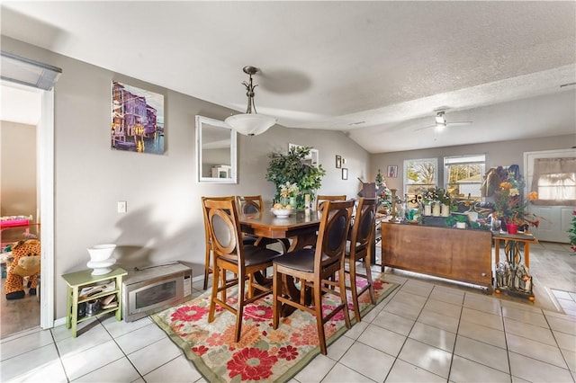 dining room with light tile patterned floors, a textured ceiling, vaulted ceiling, and ceiling fan