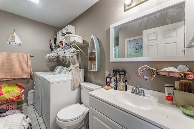 bathroom featuring vanity, toilet, tile patterned floors, and washer and dryer