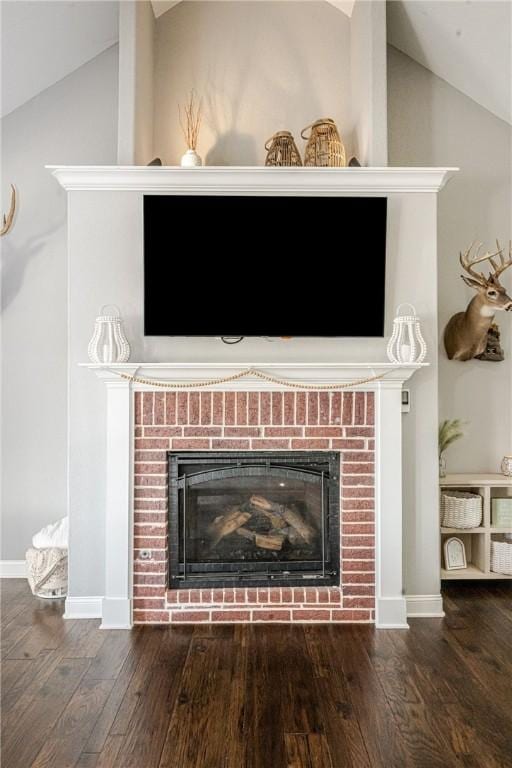 room details featuring a brick fireplace and hardwood / wood-style flooring