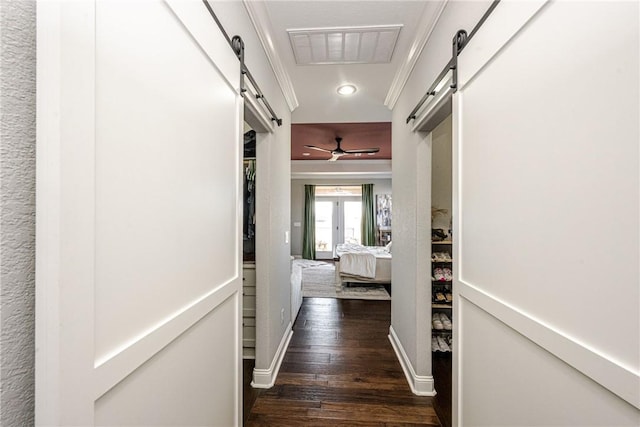 hall featuring crown molding, a barn door, and dark hardwood / wood-style flooring