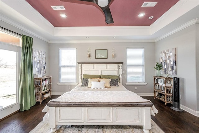 bedroom featuring a raised ceiling, crown molding, dark wood-type flooring, and ceiling fan