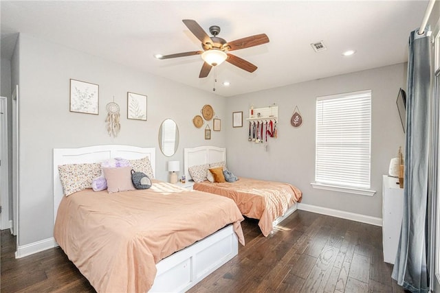 bedroom with multiple windows, dark hardwood / wood-style floors, and ceiling fan