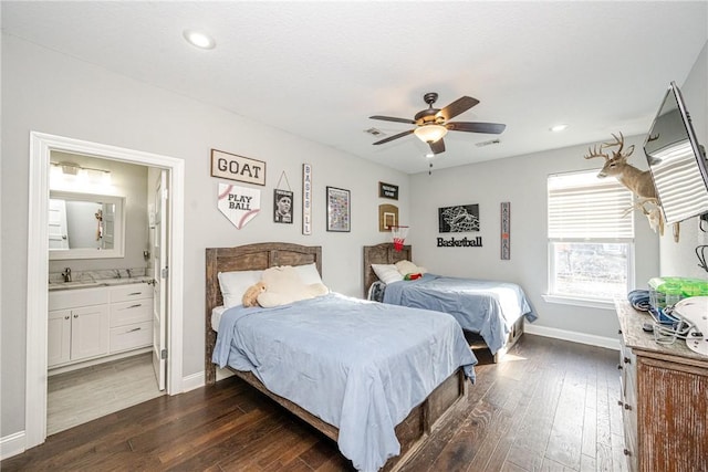 bedroom featuring dark wood-type flooring, ceiling fan, ensuite bathroom, and sink