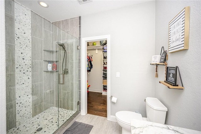 bathroom featuring an enclosed shower and toilet