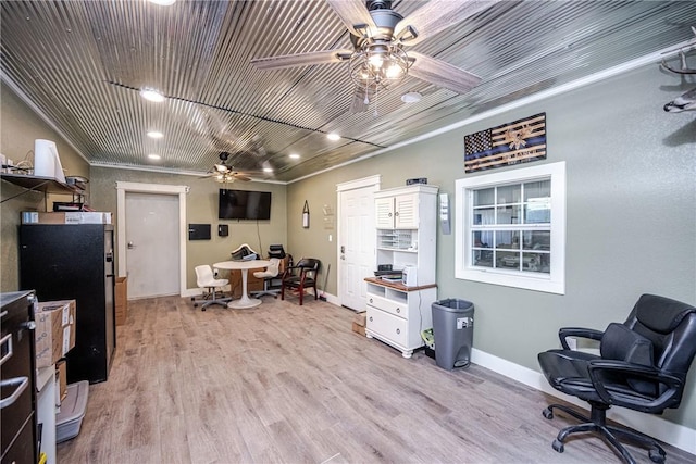 home office with crown molding, ceiling fan, and light wood-type flooring