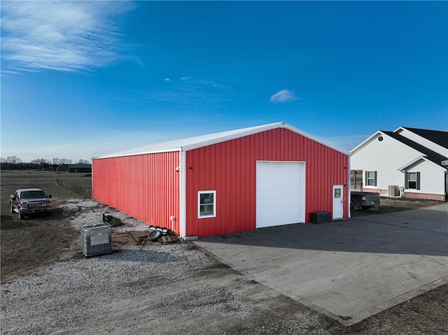 view of outbuilding with a garage and cooling unit