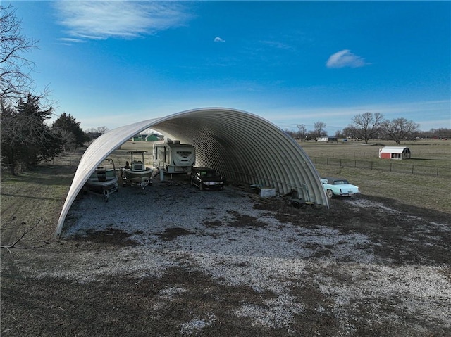 view of vehicle parking with a rural view and a carport