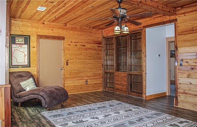 sitting room with ceiling fan, wooden walls, dark hardwood / wood-style flooring, and wooden ceiling