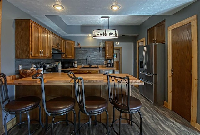 kitchen featuring stainless steel refrigerator with ice dispenser, sink, wooden counters, range with electric cooktop, and backsplash