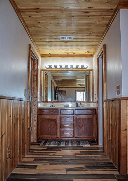 bathroom with vanity, wood-type flooring, wooden ceiling, and wood walls