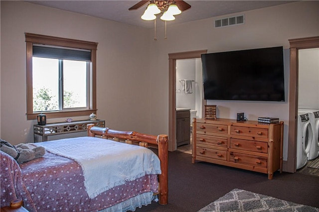 bedroom featuring ceiling fan, dark carpet, independent washer and dryer, and ensuite bath