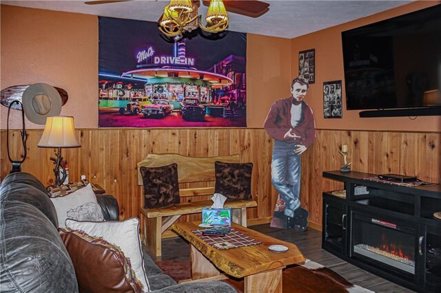 living room with ceiling fan, bar, dark hardwood / wood-style flooring, and wood walls