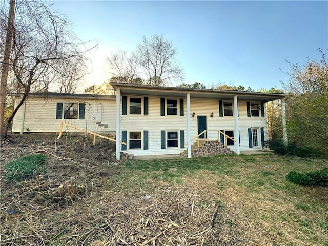 split foyer home featuring entry steps and a front lawn