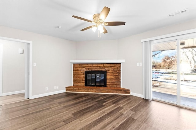 unfurnished living room with a fireplace, ceiling fan, and dark hardwood / wood-style flooring