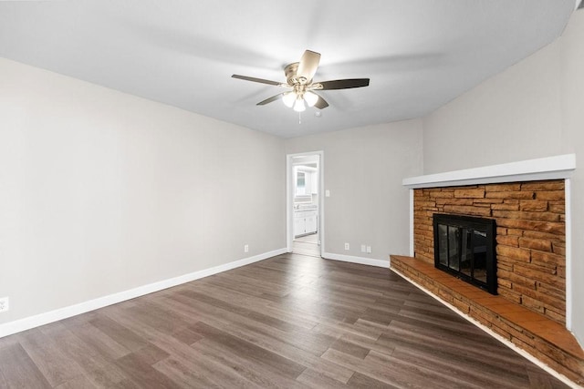 unfurnished living room with a fireplace, dark wood-type flooring, and ceiling fan