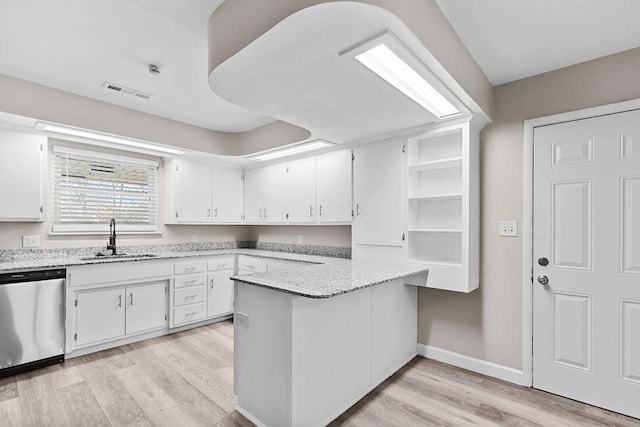 kitchen with sink, white cabinetry, light hardwood / wood-style floors, stainless steel dishwasher, and light stone countertops