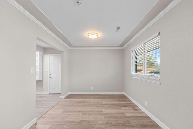 unfurnished room with ornamental molding and light wood-type flooring