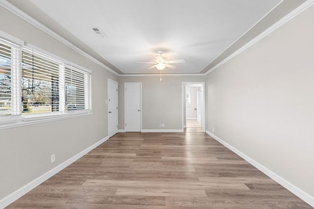 spare room featuring ceiling fan, light wood-type flooring, and crown molding