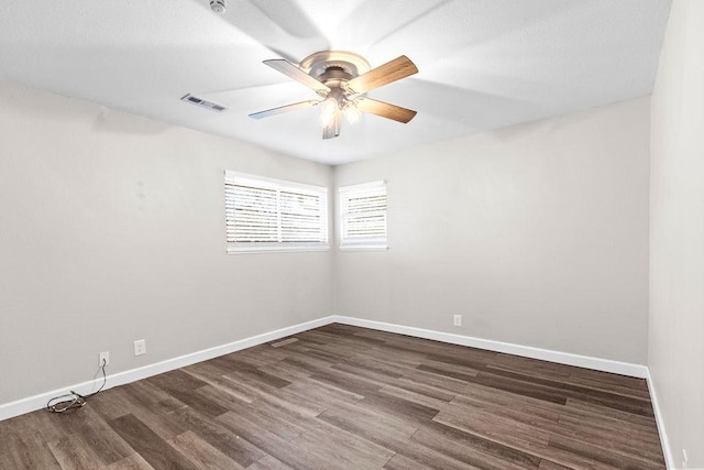 empty room with ceiling fan and dark hardwood / wood-style floors