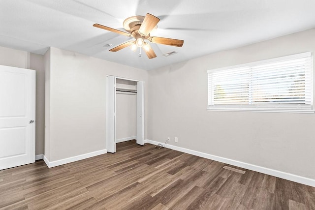 unfurnished bedroom featuring ceiling fan, a closet, and dark hardwood / wood-style flooring