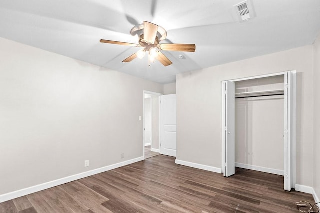 unfurnished bedroom with dark wood-type flooring, a closet, and ceiling fan