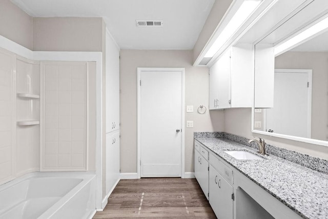 bathroom featuring tub / shower combination, hardwood / wood-style floors, and vanity