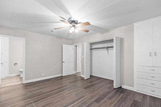 unfurnished bedroom with ceiling fan, ensuite bathroom, and dark hardwood / wood-style flooring