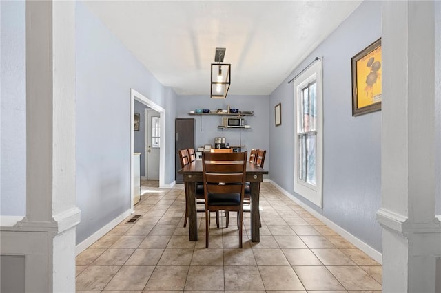 tiled dining space featuring decorative columns