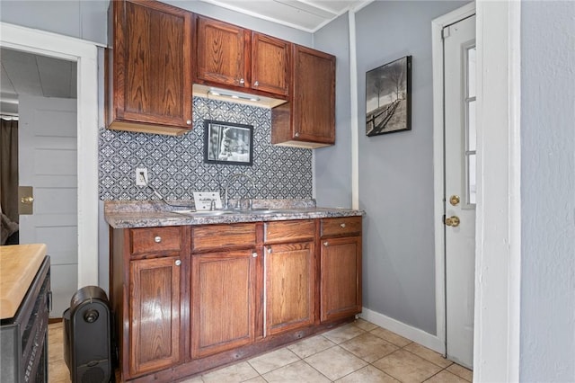 kitchen featuring decorative backsplash, sink, and light tile patterned floors