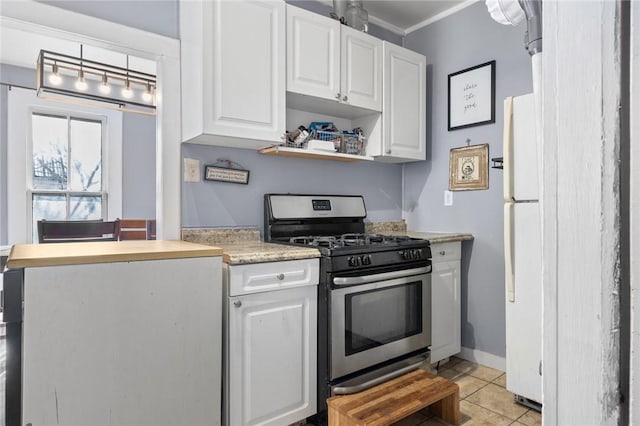 kitchen featuring light tile patterned flooring, white cabinets, crown molding, and stainless steel gas range oven