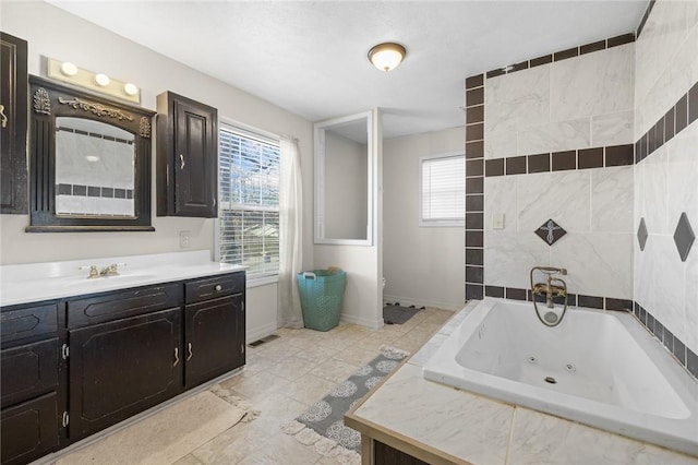 bathroom featuring tiled tub and vanity