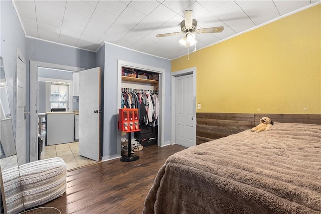 bedroom featuring wood-type flooring, a closet, ceiling fan, and ornamental molding