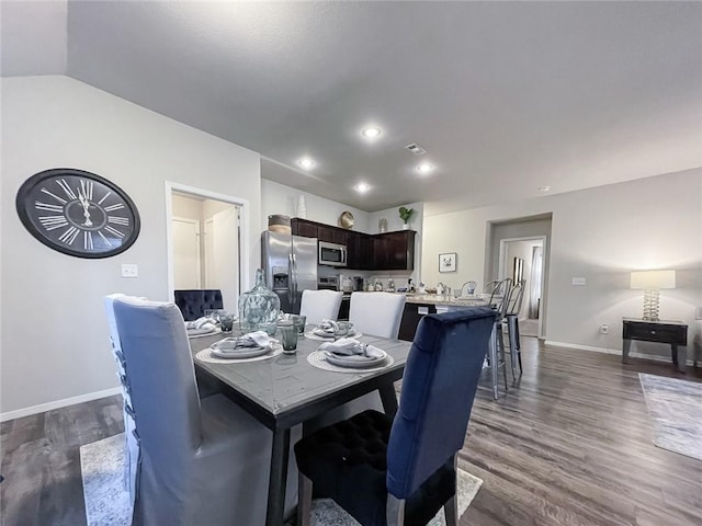 dining area featuring dark wood-type flooring and lofted ceiling