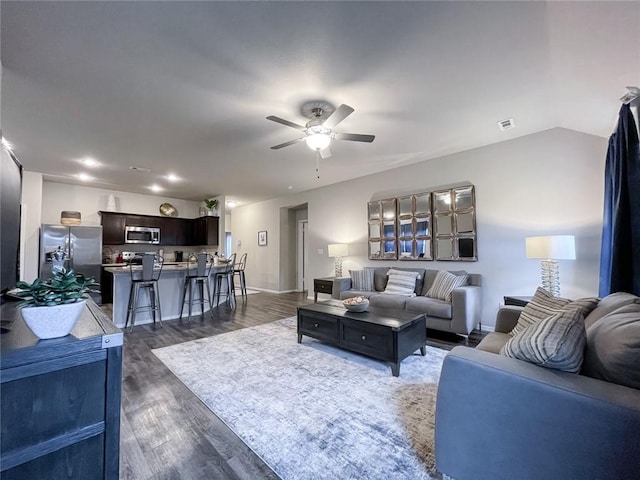 living room featuring ceiling fan and dark hardwood / wood-style flooring