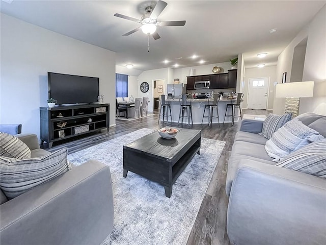 living room with ceiling fan and dark hardwood / wood-style flooring