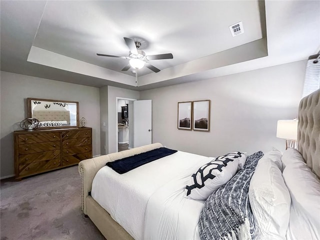 carpeted bedroom with ceiling fan and a tray ceiling