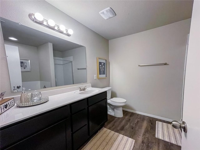 bathroom featuring vanity, toilet, walk in shower, and wood-type flooring