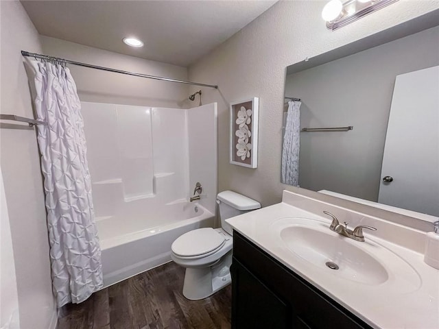 full bathroom featuring vanity, hardwood / wood-style flooring, shower / bath combo with shower curtain, and toilet