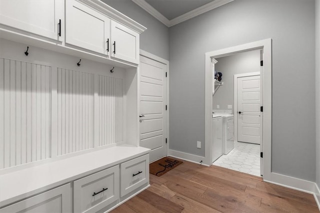 mudroom with washing machine and dryer, ornamental molding, and light hardwood / wood-style floors