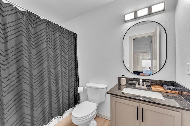 bathroom featuring hardwood / wood-style flooring, curtained shower, toilet, and vanity