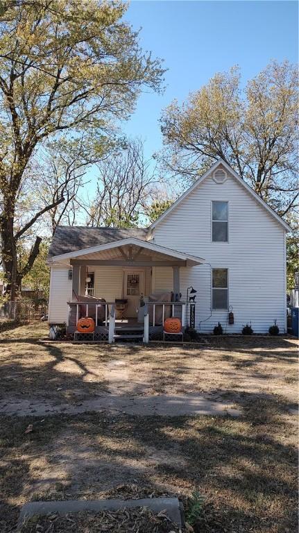 rear view of property featuring covered porch